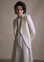 Image of a model wearing an ivory cashmere blazer layered over an ivory silk long dress.