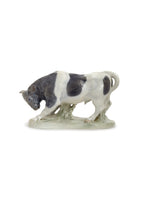 A grey and white porcelain bull figure.