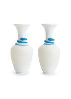 A pair of tall white vases with blue spiral detailing.