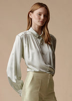 Model is wearing the pistachio blouse with pearls in silk charmeuse tucked into the pistachio Harper silk mikado pant.