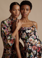 Two models posing together, one wearing the Rickie Dress in Printed Duchess and the other wearing the Sigrid Dress in Printed Crepe de Chine.