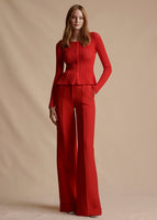 Model is wearing the Cardigan with Peplum in Pointelle Knit in the shade vermillion with the Deeda Pant in Silk Wool.