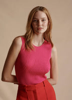 Close up of the model wearing the hot pink Shell in Silk Cashmere Ribbed Knit tucked into the Deeda pant in Vermillion.