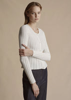 Model is wearing the ivory Cardigan with peplum in pointelle knit with the Denim Deeda Pant.