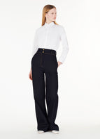 model wearing the shirt with thin bow in white with the hugo pant in indigo denim
