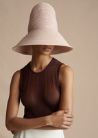 A close up of a model wearing the Shell in Metallic Rib, paired with the Cleo Hat.