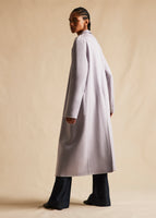A side-view image of a model wearing a long lavender cashmere coat.
