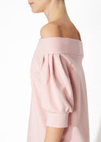 A detailed view of a blush off the shoulder dress.