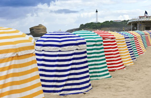 An image of striped umbrellas on a beach.