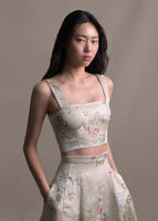 Model wearing cropped champagne jacquard tank top with floral detail paired with matching skirt