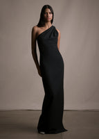 Model wearing a floor length black satin one shoulder gown with wrap ribbon detail. 