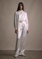 Model wearing long straight leg double-pleat pant in ivory with matching blouse