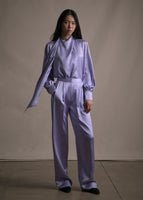 Model wearing straight leg double pleat pant in lavender with a matching blouse.