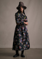 Model wearing a floor length flare skirt with multicolor printed flowers with a matching top.