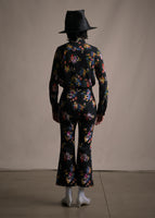 A back-facing image of a model wearing a cropped black pant with floral print and a slight flare with a matching top