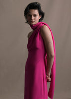 A zoomed in image of a model wearing a hot pink satin one shoulder gown with wrap ribbon detail. 