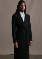 Model wearing white top under black manteau in metallic tweed.