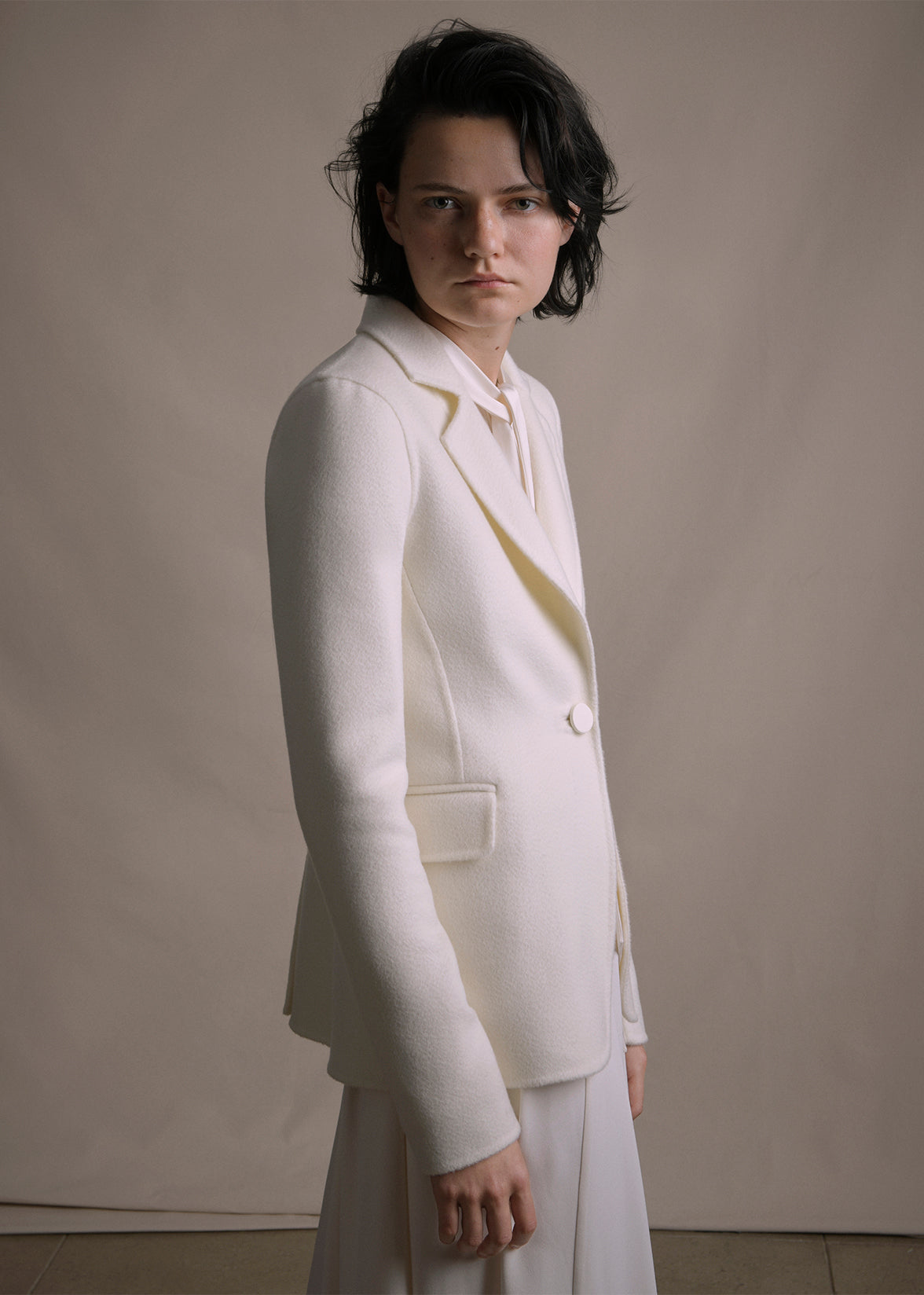 Image of a model wearing an ivory cashmere blazer by Adam Lippes