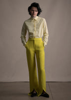 Model wearing long citrine pant with a slit front paired with a yellow blouse.