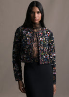 Model wearing long sleeve front-zip multicolor flower embroidered black bolero worn with black skirt and lace top.
