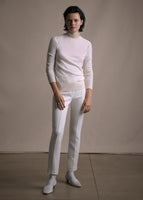 Image of a model facing forward wearing white crewneck sweater and white cigarette pant