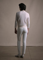 Image of a model facing backward wearing white crewneck sweater and white cigarette pant.