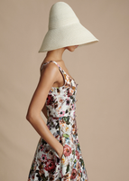 Side profile of model wearing the Cleo Hat in Ivory and the Amelie Dress in Cotton Twill.