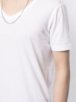 Model is wearing a white short sleeve v-neck t-shirt in pima cotton.