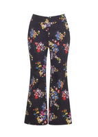 Flat lay of a cropped black pant with floral print and slight flare in printed cotton.