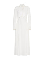 A flat lay of an ivory long sleeved silk mid length dress.  Has a self fabric bow at the front neck.