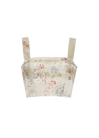 Flat lay of a cropped champagne jacquard tank top with floral detail.