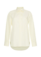 Flat lay of white and citrine long sleeve shirt with collar and thin bow in stripe shirting.