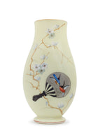 Cream colored vase with gold trim featuring floral and bird detailing.