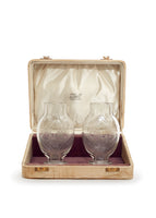 A pair of small crystal glasses in a case.