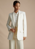 A cropped in image of a model wearing the Tux Jacket in Radzimir Wool in White, styled with the Deeda Pant in Silk Wool.
