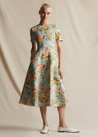 A model facing forward wearing a light blue floral short sleeved dress.