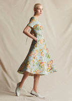 An image of a model wearing a short sleeved pale blue floral fit and flare mid length dress.