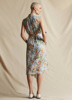 A model standing backwards wearing a blue floral printed sleeveless dress.