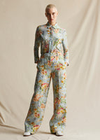 Model wearing a pale blue floral wide leg pant, with a matching pale blue floral long sleeved shirt.