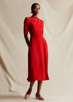 A model wearing a red midi silk short sleeved dress.