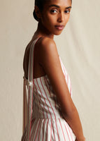 A close-up image of a model wearing a red and white striped sleeveless dress