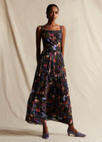 Model wearing a black floral long pleated sleeveless dress.