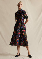 A model wearing a black ground floral midi dress.