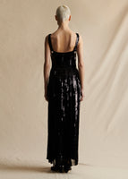 Model standing backwards wearing a black sleeveless long dress. 