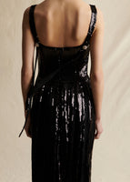 Close-up image of crystal buttons on long black sleeveless sequin dress.