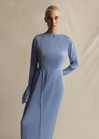 A model wearing a pleated light blue midi dress with thin tie at the waist.