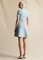 An image of a model standing backwards wearing a light blue short sleeved knit dress short dress.