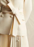 Close-up image of the belt tied on the ivory blazer