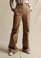 Close-up Image of a khaki pant with pintuck down each leg and cuffed hem. Image on model from waist down.