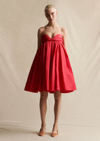 Image of a model wearing a red pleated dress with thin straps.